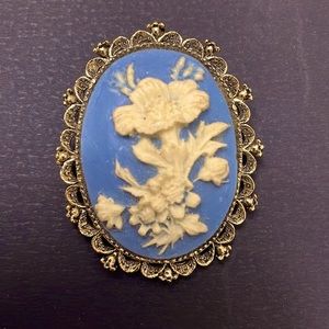 Antique blue brooch (stamped) with etched off-white flower. Ornate gold trim